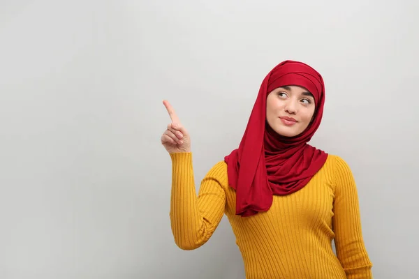 Muslimische Frau Hijab Zeigt Auf Etwas Auf Hellgrauem Hintergrund Raum — Stockfoto