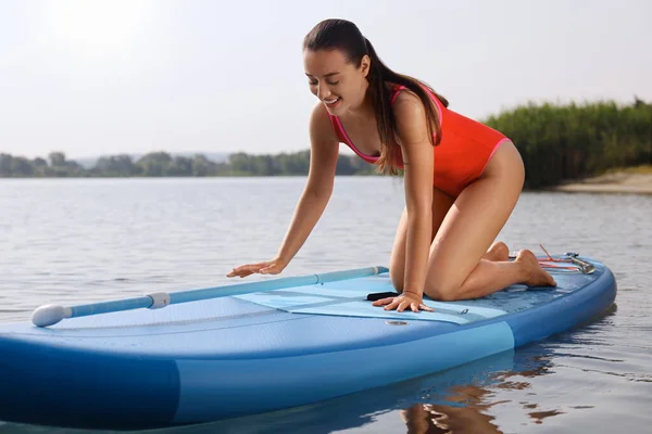 Woman with paddle on SUP board in sea