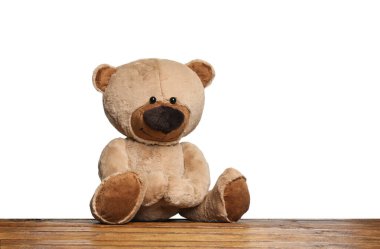 Cute teddy bear on wooden table against white background clipart