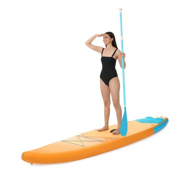Beyaz arka planda turuncu SUP tahtasıyla kürek çeken mutlu bir kadın.