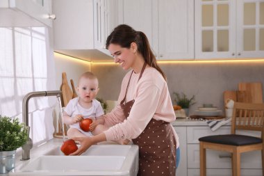 Anne ve küçük tatlı bebeği mutfakta vakit geçiriyorlar, mesaj atmak için yer var.