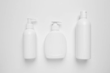 Beyaz arka planda farklı kozmetik ürünleri olan şişeler, düz konum