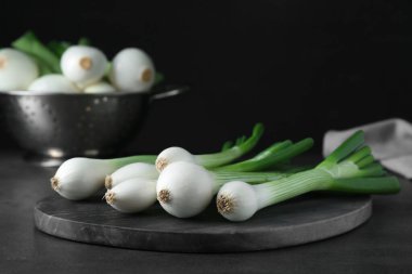 Tüm yeşil taze soğanlar siyah masada, yakın plan.