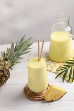 Lezzetli ananas püresi ve beyaz ahşap masada meyve.