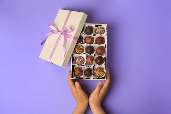 Barn Med Låda Med Läckra Choklad Godis Ljus Lila Bakgrund — Stockfoto