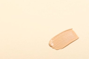 Bej arka planda cilt temeli lekesi, üst manzara. Metin için boşluk