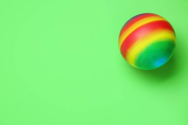 Açık yeşil arka planda parlak lastik çocuk topu, üst manzara. Metin için boşluk