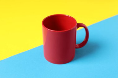 Renkli arka planda bir kırmızı seramik kupa