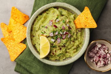 Bir kase lezzetli guacamole, cips ve limon.