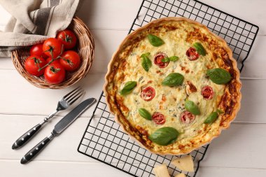 Lezzetli ev yapımı peynirli kiş, malzemeler ve çatal bıçak takımı beyaz ahşap masa, düz uzanma