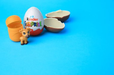 Slynchev Bryag, Bulgaristan - 25 Mayıs 2023: Açık mavi arka planda Kinder Sürpriz Yumurtalar, plastik kapsül ve oyuncak geyik, metin için alan