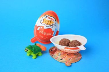 Slynchev Bryag, Bulgaristan - 25 Mayıs 2023: Tatlı şekerli Kinder Joy Egg ve açık mavi arka planda oyuncak kaplumbağa