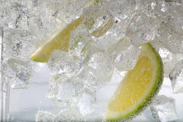 Saftige Limettenscheiben Und Eiswürfel Sodawasser Vor Weißem Hintergrund Nahaufnahme — Stockfoto