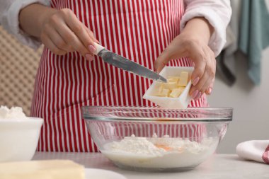 Lezzetli baklava yapıyorum. Kadın kaseye tereyağı ve un ekliyor, yakın plan.