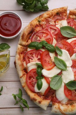 Domatesli lezzetli Caprese pizzası, mozzarella ve fesleğen açık ahşap masa, düz uzanma