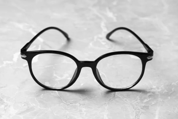 Okulary Stylowej Ramce Szarym Marmurowym Stole Zbliżenie — Zdjęcie stockowe