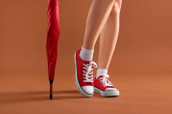 Kırmızı Eski Tarz Spor Ayakkabılı Kahverengi Arka Planda Şemsiyeli Bir — Stok fotoğraf