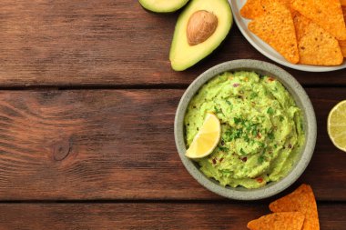 Tahta masada bir kase lezzetli guacamole ve cips. Metin için boşluk