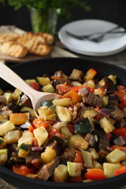 Yemek masasında leziz ratatouille ve kaşık, yakın plan.