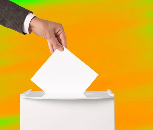 男子将选票放在彩色背景的投票箱里 特写镜头 — 图库照片