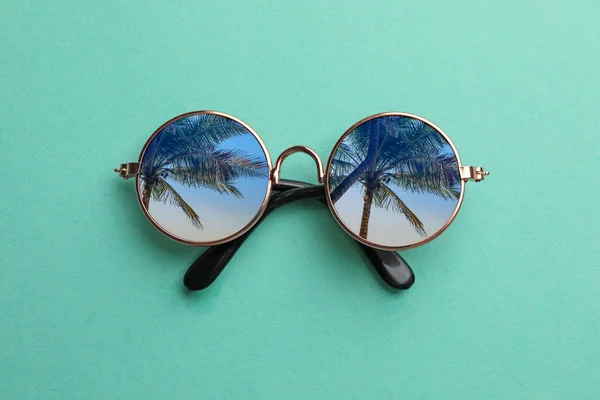 Elegante Zonnebril Turquoise Achtergrond Bovenaanzicht Lucht Palmbomen Reflecteren Lenzen — Stockfoto