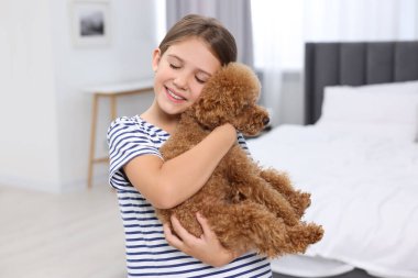 Yatak odasında köpek yavrusu olan küçük bir çocuk. Sevimli hayvan