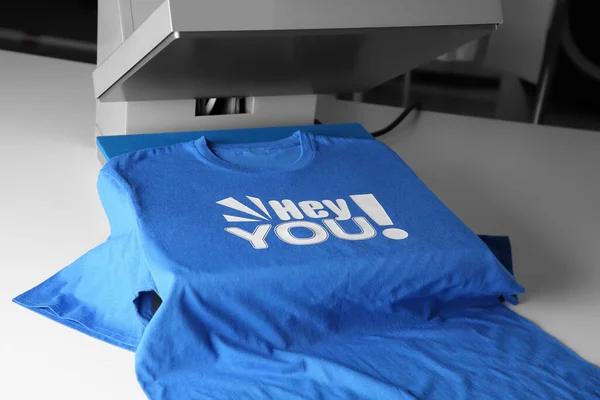 Logo Impresión Prensa Calor Con Camiseta Azul Sobre Mesa Blanca —  Fotos de Stock