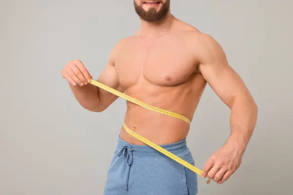 Atletische Man Meten Taille Met Tape Lichtgrijze Achtergrond Close Gewichtsverlies — Stockfoto