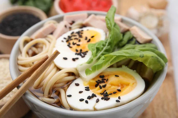 Tahta tahtada etli ve yumurtalı ramen tabağı, yakın plan. Erişte çorbası.