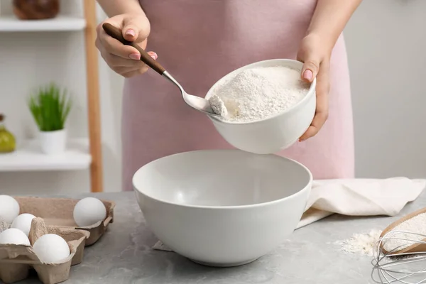 stock image Preparing tasty baklava. Woman putting flour into bowl at light grey marble table, closeup