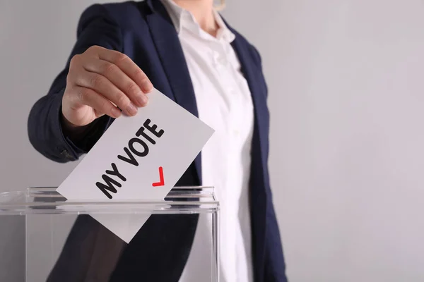女性はテキストで紙を置く 私の投票と軽い灰色の背景に投票箱にチェック — ストック写真