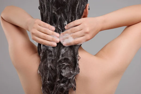 Žena Praní Vlasů Šedém Pozadí Detailní Záběr — Stock fotografie