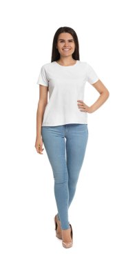 Beyaz arka planda açık mavi kot ve yüksek topuklu ayakkabı giyen mutlu bir kadın.