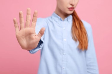 Pembe arka planda dur hareketi gösteren kadın, yakın plan