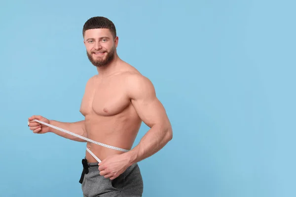 Portret Van Vrolijke Atletische Man Meten Taille Met Tape Lichtblauwe — Stockfoto