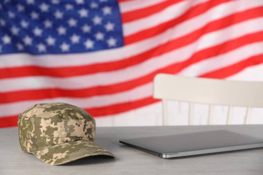 Kaptan ve dizüstü bilgisayar ahşap masada Amerikan bayrağına karşı. Askeri eğitim