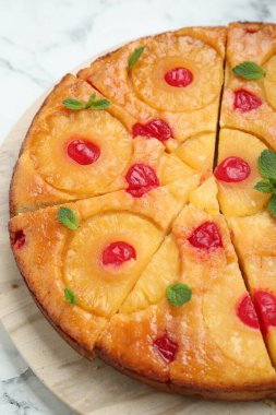 Kirazlı ve nane aromalı nefis ananas turtası, beyaz mermer masa, yakın plan.