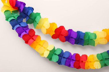 Bej arka planda gökkuşağı kağıt çelenkleri. LGBT gururu