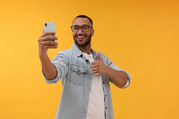 Joven Sonriente Tomando Selfie Con Smartphone Mostrando Los Pulgares Hacia —  Fotos de Stock