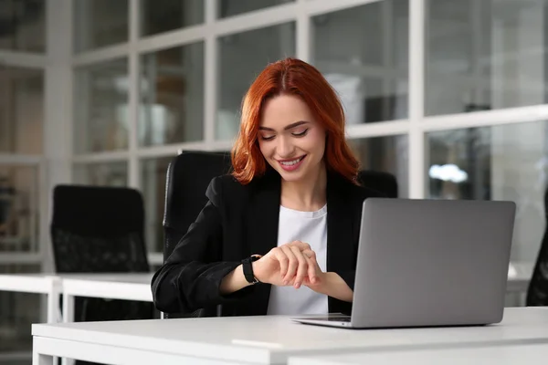 Mujer Feliz Comprobando Tiempo Mientras Trabaja Con Ordenador Portátil Escritorio — Foto de Stock