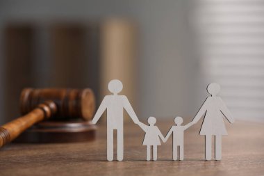 Aile hukuku. Çocuklu ebeveyn figürü ve tahta masa üzerinde tokmak, metin için alan