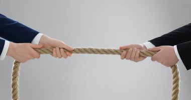 Tartışma konsepti. Açık gri arka planda ipi çeken adamlar, yakın plan.