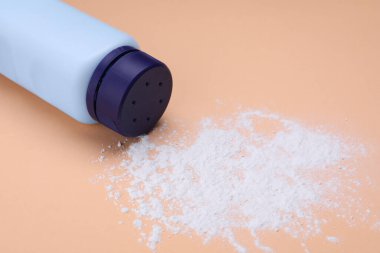 Soluk mercan zemin üzerinde şişe ve toz alma tozu. Bebek kozmetik ürünü