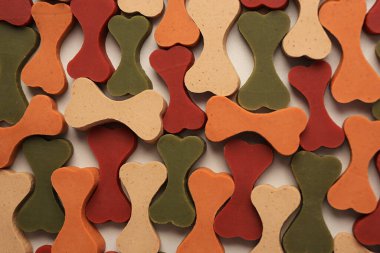 Bej arka planda evcil hayvanlar için kemik şekilli vitaminler içeren düz bir bileşim.