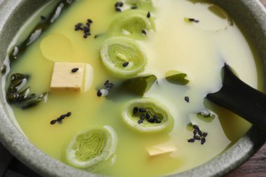 Bir kase lezzetli miso çorbası, tofu ve kaşıkla, yakın plan.