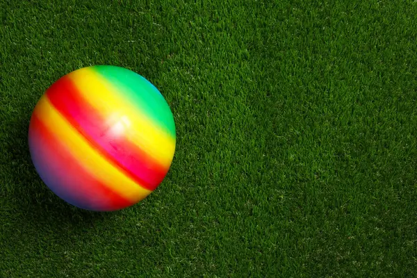 新的明亮的孩子的球在人造绿色的草地上 顶部的视野 案文的篇幅 — 图库照片