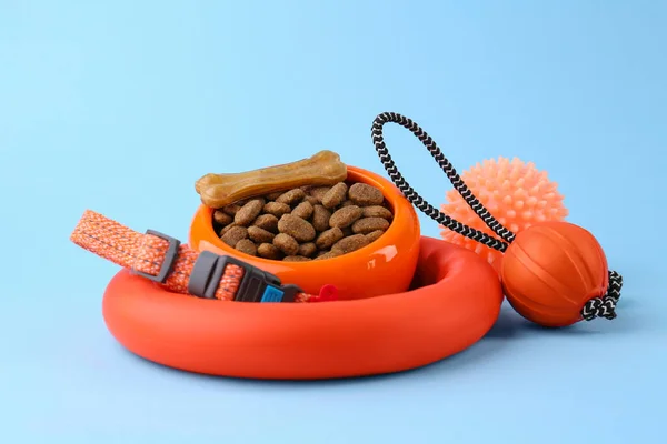 Dry pet food and toys on light blue background. Shop items