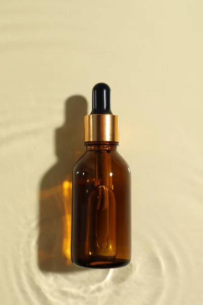 Bottiglia Olio Cosmetico Acqua Sfondo Beige Vista Dall Alto — Foto Stock