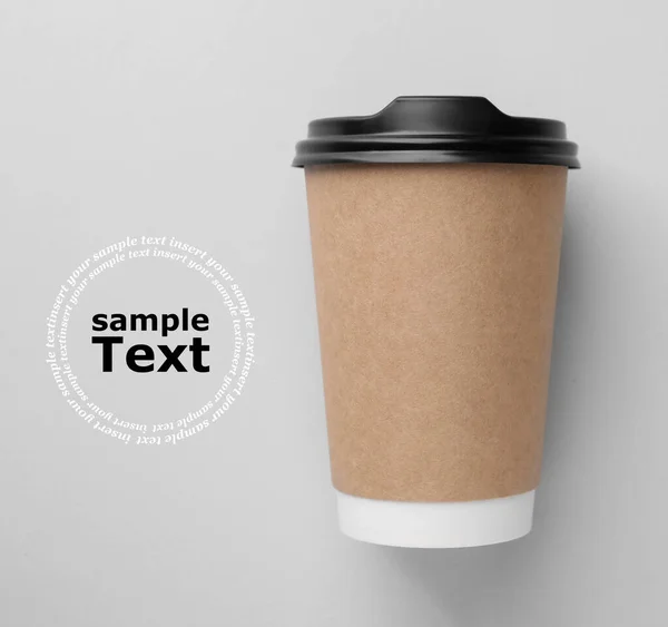 Coffee to go. Paper cup with plastic lid on light gray background, top view. Design with space for your text