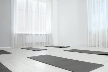 Egzersiz paspasları olan geniş bir yoga stüdyosu. Metin için boşluk